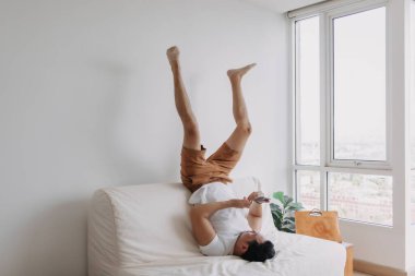 Funny asian man using phone in a boring time. Concept of time and boring.