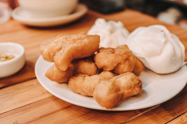 Tayland kahvaltısı. Pirinç lapası ve Pa Tong. Tahta masada..