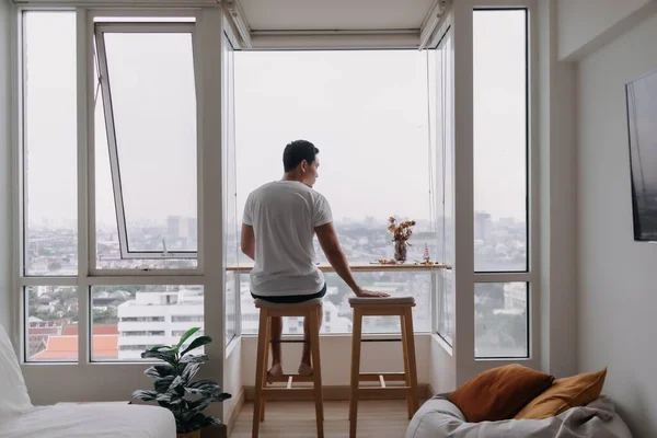 Lonely asian man sit by windows in the room. Concept lonely single broken heart.