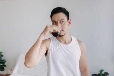 Asian man dink a shot of espresso coffee in his house for a fresh morning.