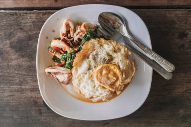 Tayland pilavı, kızarmış kalamar, fesleğen ve sahanda yumurta..