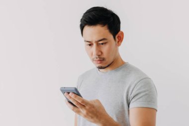 Asian man seriously concentrated on smartphone isolated on white background.