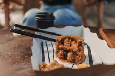 Kahve kafesinde plastik çatal ve kaşıkla karton kutuda servis edilen ısırık keki..