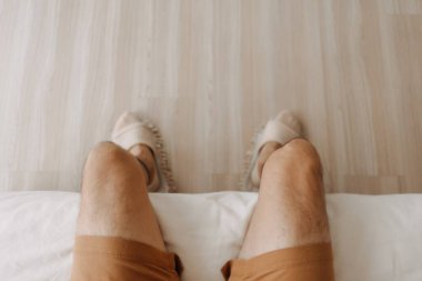 Top view of relax man sitting on sofa with crossing legs in cozy loft room.