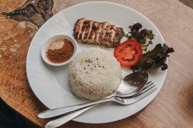 Masada servis edilen beyaz pirinçli Tayland usulü tavuk.