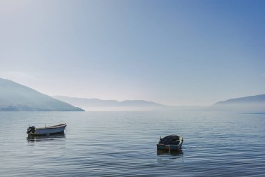 Small boat floating on the empty quiet sea. Concept of calm and serenity.