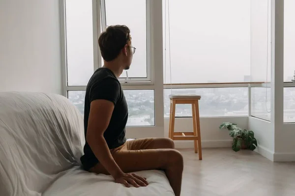 孤独なアジアの男はソファの上に必死に彼のアパートに横たわっている — ストック写真