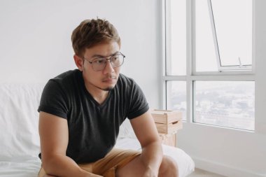 Yalnız Asyalı bir adam dairesinde tek başına oturuyor. Depresyon kavramı.