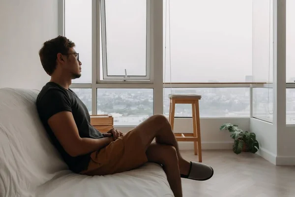 외로운 아시아 남자가 소파에 필사적으로 자신의 아파트 — 스톡 사진