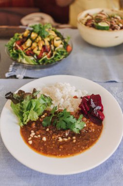 Restoranda beyaz tabakta servis edilen turşulu Japon körili pilavı..