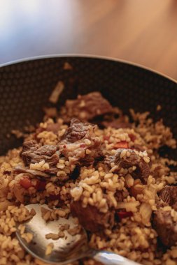 Siyah demir tavada servis edilen ev yapımı sığır eti pilavı..