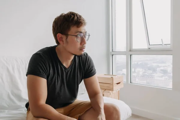 Lonely Asian man sitting lonely in his apartment. Concept of depression.