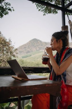 Kafede seyahat ederken internetten çalışan Asyalı turist kadın..