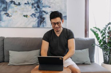 Kafede tabletiyle çalışan serbest çalışan Asyalı bir adam..