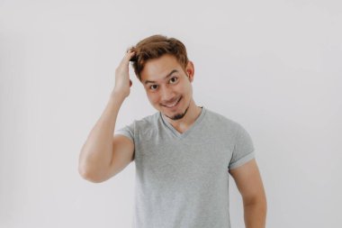 Gri tişörtlü Asyalı adam saçlarını beyaza boyadığı için mutlu..