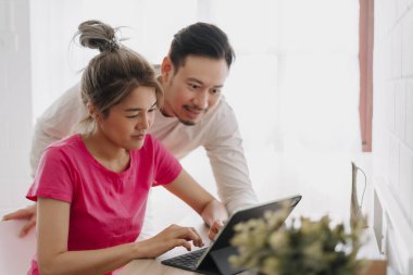 İnternetteki reklam hizmeti teklifine bakan mutlu Asyalı çift.