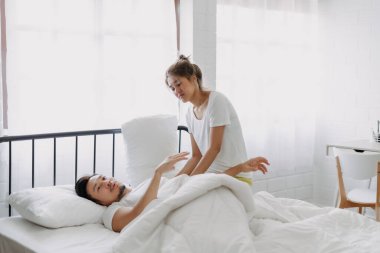 Komik, sevimli Asyalı çift. Eş sabah kocasını uyandırmaya çalışıyor..