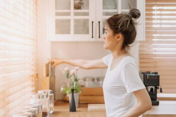 Wanita Asia Melihat Keluar Jendela Dari Dapur Putih Yang Hangat — Stok Foto
