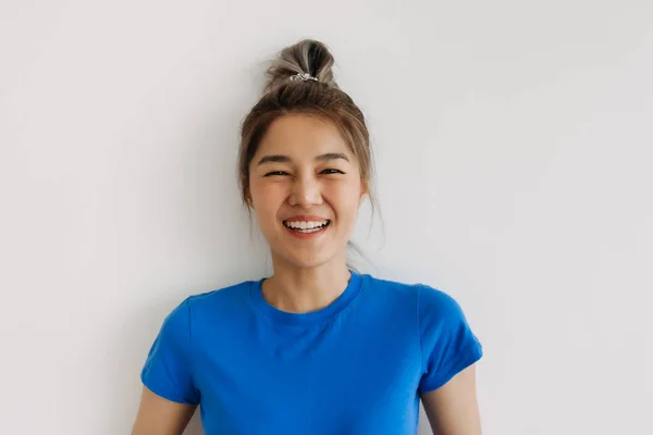 白いシャツに隔離された青のTシャツで幸せなアジアの女性のクローズアップ — ストック写真