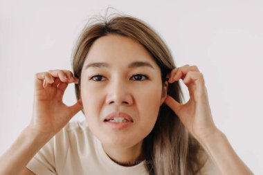 Asyalı bir kadın, beyaz bir mizah anlayışı için komik bir yüz ifadesi sergiliyor..