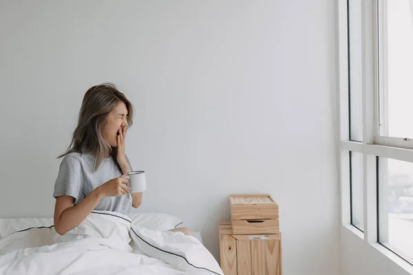 Asyalı Kadın Beyaz Yatak Odasında Boş Bir Fincan Kahve Tutuyor — Stok fotoğraf