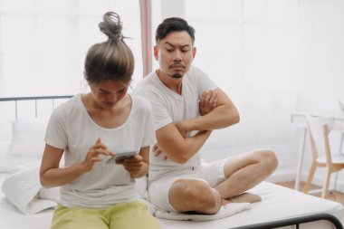 Asyalı koca gizlice karısını gözetliyor. Eğer bir ilişkisi varsa telefonda sohbet ediyor..