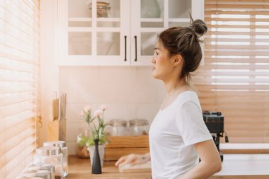 Beyaz, sıcak mutfaktan dışarı bakan Asyalı kadın..