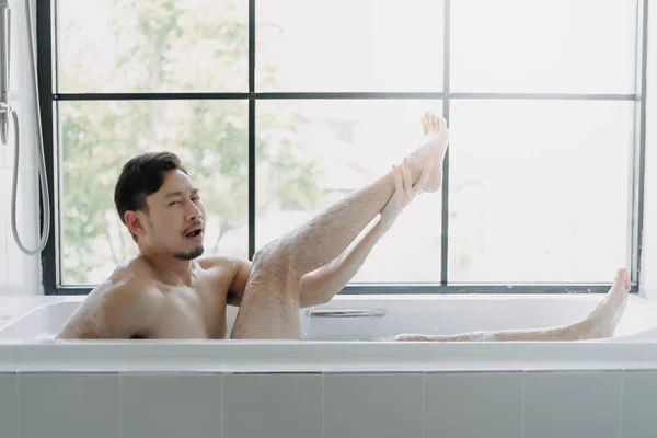 Grappige Aziatische Man Liggend Badkuip Tonen Zijn Been Doen Alsof — Stockfoto