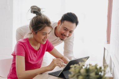 Asyalı çift aşığı birbirine problemi çözmeyi ve online çalışmayı öğretiyor..