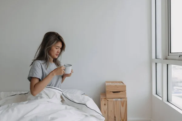 亚洲女人早上一醒来就在床上喝咖啡 — 图库照片