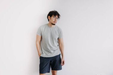 Sıkıcı yüzlü Asyalı adam, bembeyaz bir bedende sıkıcı bir şekilde dikiliyor..