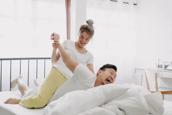 Funny Asian Couple Wife Giving Husband Hurt Massage White Bedroom — Stock Photo, Image