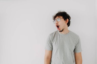 Sıkıcı Asyalı adam reklamını sunuyor. Beyaz ağızla izole edilmiş şok olmuş..