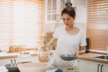 Asyalı bir kadın mutfakta basit erişte pişirmekten zevk alır..