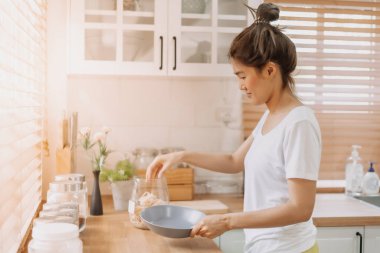Asyalı kadın sabah mutfakta kahvaltı hazırlıyor..