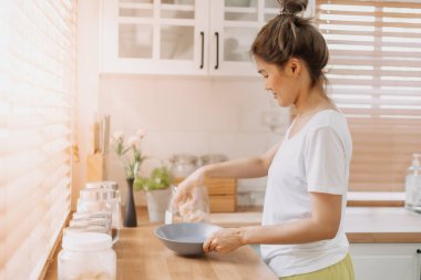 Asyalı kadın sabah mutfakta kahvaltı hazırlıyor..