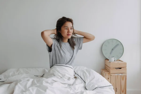 アジアの女性は朝7時にベッドの上で目を覚ます — ストック写真
