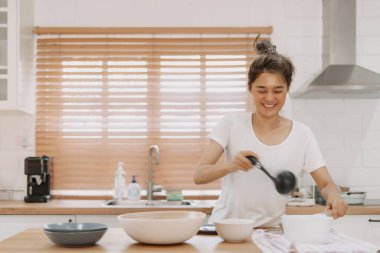 Asyalı kadın servis edilecek çorbayı getiriyor..