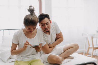 Asyalı koca gizlice karısını gözetliyor. Eğer bir ilişkisi varsa telefonda sohbet ediyor..