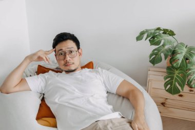 Mutlu Asyalı adam, bir gün oturma odasındaki armut çuvalında rahatla..