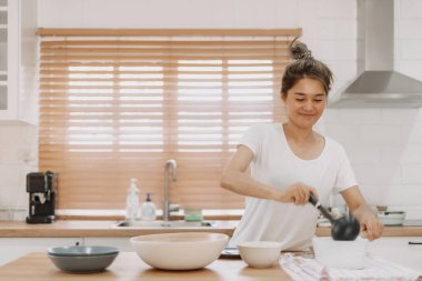 Asyalı kadın servis edilecek çorbayı getiriyor..