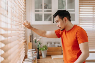 Asyalı adam sabah mutfakta sakin sakin kahvaltı hazırlıyor..