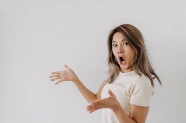 Beyaz arka planda izole edilmiş Asyalı bir kadının şaşırmış ve şaşırmış yüzü..