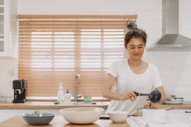 Asyalı kadın servis edilecek çorbayı getiriyor..