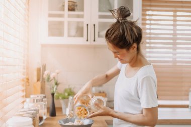 Asyalı kadın sabah mutfakta kahvaltı hazırlıyor..