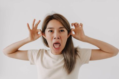 Asyalı bir adam, beyaz bir mizah anlayışı için komik bir yüz ifadesi sergiliyor..