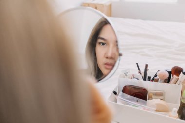 Aynada makyaj yapan Asyalı kadın. Alet edevat ve teçhizatla..