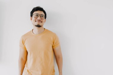 Sarı tişörtlü ve gözlüklü Asyalı beyaz tenli mutlu titreşimler..