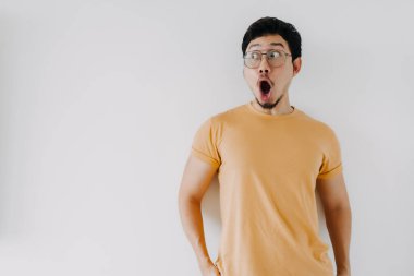 Komik Asyalı adam. Vay ve şok olmuş yüz. Sarı tişört giy..