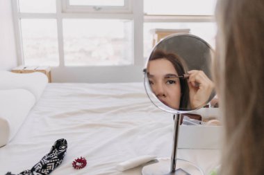 Aynada makyaj yapan Asyalı kadın. Alet edevat ve teçhizatla..